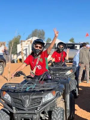 two men riding on four wheeled vehicles at Luxury Suerte Camp in Merzouga
