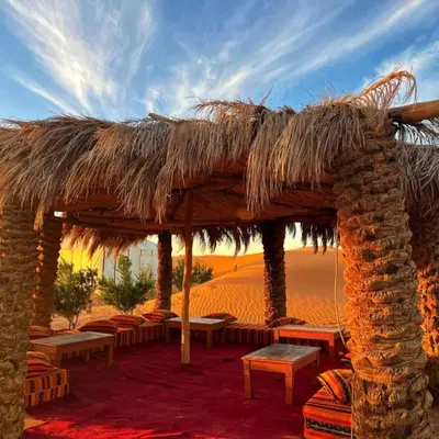 a straw hut in the middle of the desert at Luxury Suerte Camp in Merzouga