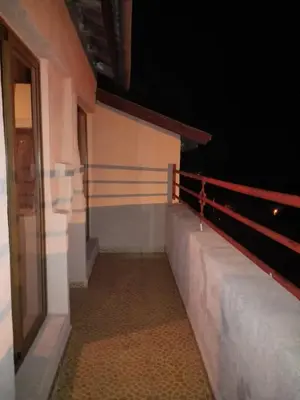 a balcony of a building at night with a railing at appartement chalet in Imouzzer Kandar