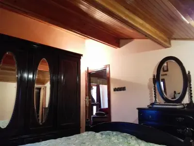 a bedroom with a dresser and a mirror and a bed at appartement chalet in Imouzzer Kandar