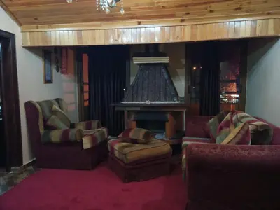 a living room with couches chairs and a fireplace at appartement chalet in Imouzzer Kandar