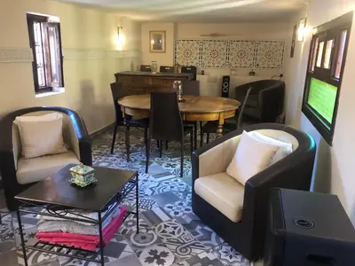 a living room with chairs and a table and a television at Riad Inaya Fez in Fès