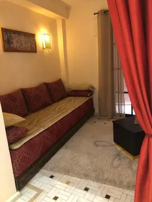 a couch in a room with red curtains at Riad Inaya Fez in Fès