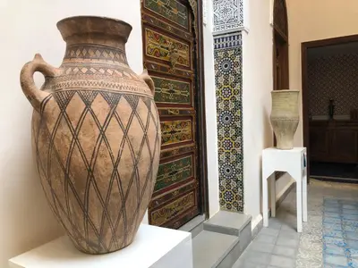 a large vase sitting on a table next to a door at Riad Inaya Fez in Fès