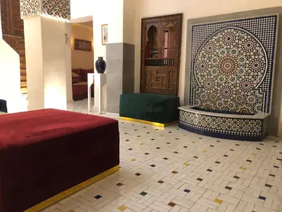 a room with a bed and a door with a tile floor at Riad Inaya Fez in Fès