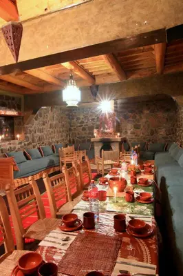 a dining room with a long table with dishes on it at Tigmi Tachddirt in Tacheddirt