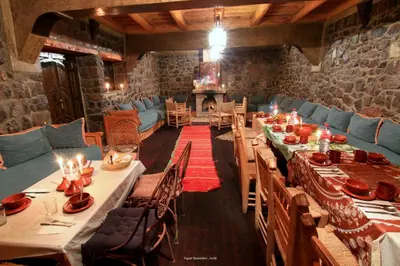 a dining room with long tables and blue chairs at Tigmi Tachddirt in Tacheddirt