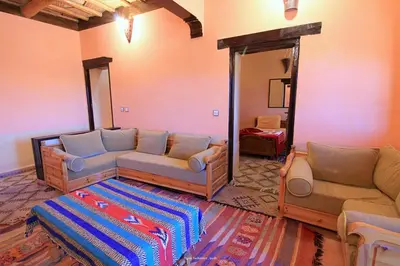 a living room with two couches and a mirror at Tigmi Tachddirt in Tacheddirt