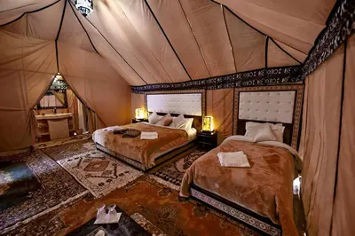 a bedroom with two beds in a tent at Golden Camel Desert Camp - Merzouga Luxury Camp in Merzouga