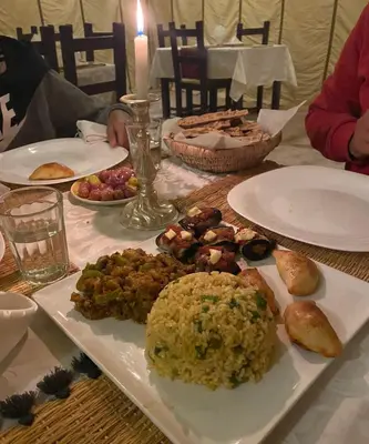 a table with plates of food on top of it at Golden Camel Desert Camp - Merzouga Luxury Camp in Merzouga