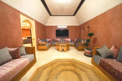a living room with couches and a flat screen tv at Spacious villa with pool near Marrakech in Douar bel Rhanodour