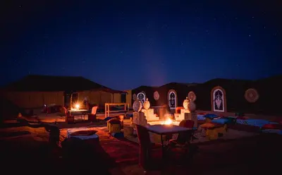 a night scene of a desert with a starry sky at Chegaga Nomad Camp in El Gouera