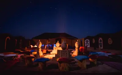 a night view of a display with umbrellas under the stars at Chegaga Nomad Camp in El Gouera