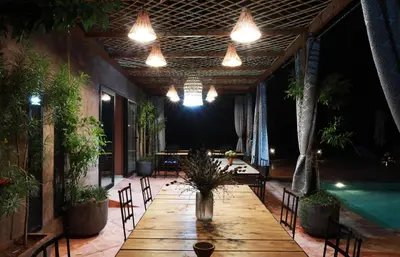 a patio with a table and a swimming pool at Le petit Château des Anges in Marrakech