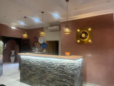 a bar in a room with a stone wall at Le petit Château des Anges in Marrakech