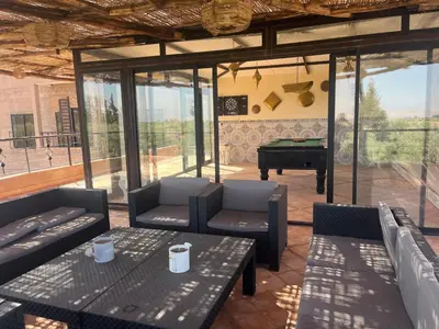 a patio with couches and a table and a piano at Le petit Château des Anges in Marrakech