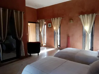 a bedroom with two white beds and windows at Le petit Château des Anges in Marrakech
