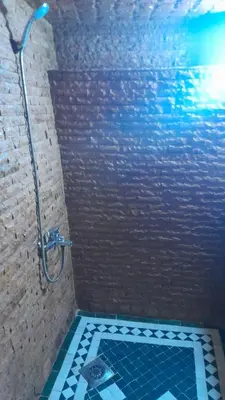 a bathroom with a shower with blue tiles on the floor at Riad amal in Fès
