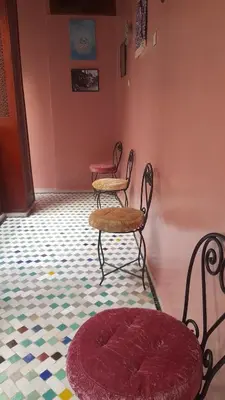 a room with two chairs and a table and a rug at Riad amal in Fès