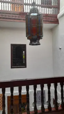 a chandelier hanging from a staircase in a building at Riad amal in Fès