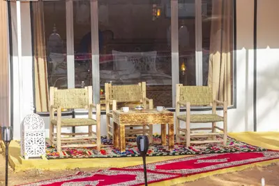 a group of chairs and a table and a table and a table and chairs at Morocco Luxury Desert Camp in Merzouga