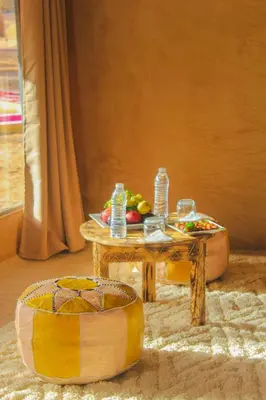 a table with a tray of fruit and water on it at Morocco Luxury Desert Camp in Merzouga