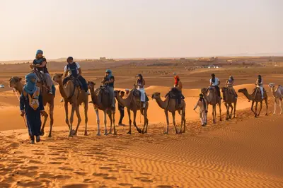 a group of people riding on horses in the desert at Morocco Luxury Desert Camp in Merzouga