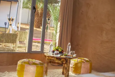 a table and two chairs and a table with fruit on it at Morocco Luxury Desert Camp in Merzouga