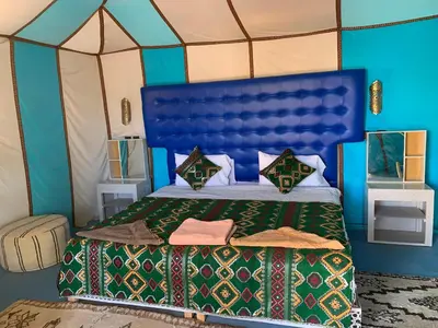 a bedroom with a bed in a tent at Tafouyte Luxury Camp in Merzouga