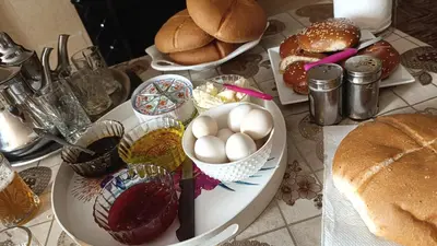 a table with a plate of food with eggs and bread at Tafouyte Luxury Camp in Merzouga