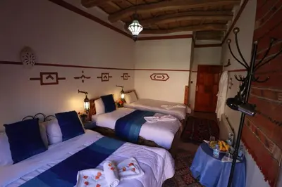 a bedroom with two beds and a lamp in it at Maison d'Hôte Argana in Aït Idaïr