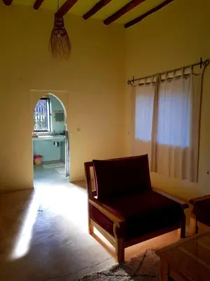 a living room with a couch and a window at Ourika Timalizène le jardin des délices in Tamzerdirt