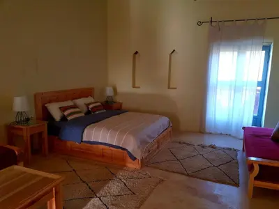 a bedroom with a bed with a sign on the wall at Ourika Timalizène le jardin des délices in Tamzerdirt