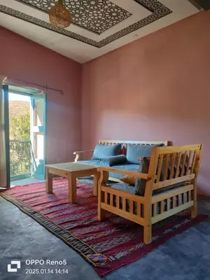 a living room with a couch and a table at Ourika Timalizène le jardin des délices in Tamzerdirt