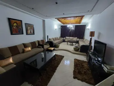 a living room with a couch and a tv at Beautiful Apartment Hamria in Meknès