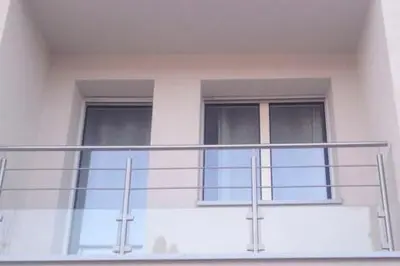a balcony of a white building with two windows at Beautiful Apartment Hamria in Meknès