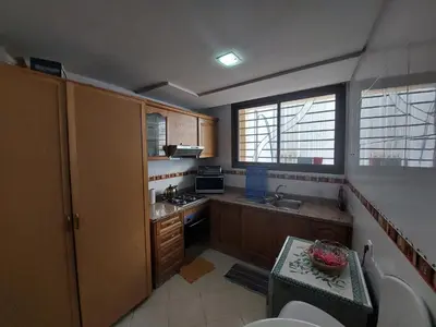 a kitchen with wooden cabinets and a sink and a toilet at Beautiful Apartment Hamria in Meknès