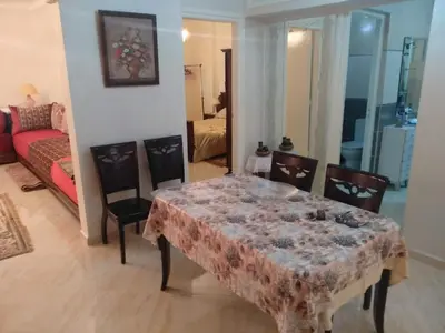 a living room with a table and chairs and a couch at Apartment Centre Meknes in Meknès