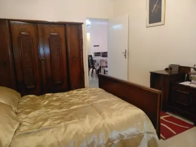 a bedroom with a bed and a dresser and a desk at Apartment Centre Meknes in Meknès