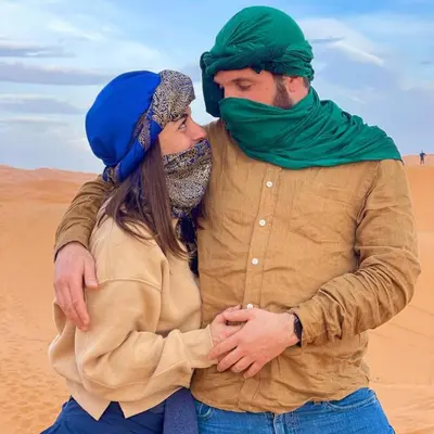 a man and a woman standing in the desert at Desert Lover's Luxury Camp in Merzouga