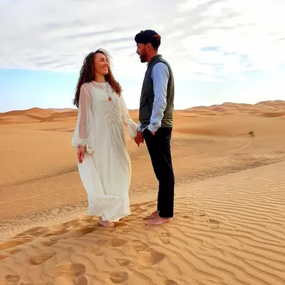 a bride and groom standing in the desert at Desert Lover's Luxury Camp in Merzouga