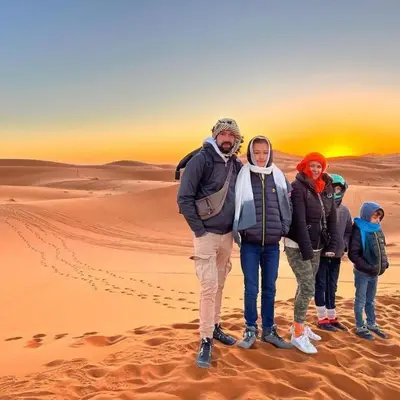 a group of people standing in the desert at Desert Lover's Luxury Camp in Merzouga