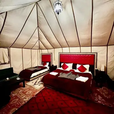 a bedroom with two beds in a tent at Desert Lover's Luxury Camp in Merzouga