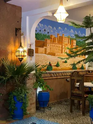 a restaurant with a mural on the wall at Hôtel Bia Besta in Boumalne