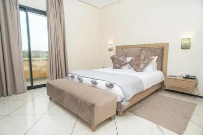 a bedroom with a large bed and a large window at HOTEL DES THERMES in Tarmilet