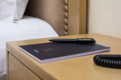 a pen sitting on top of a table next to a bed at HOTEL DES THERMES in Tarmilet