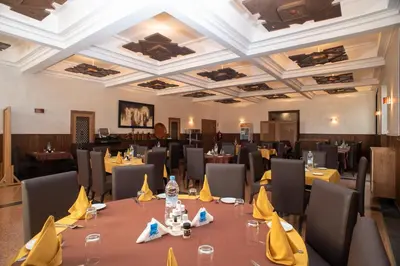 a dining room with tables and chairs with yellow napkins at HOTEL DES THERMES in Tarmilet
