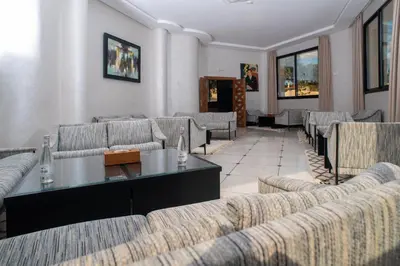 a living room with couches and a table and chairs at HOTEL DES THERMES in Tarmilet
