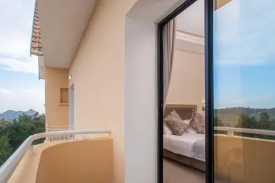 a bedroom with a bed and a balcony with a view at HOTEL DES THERMES in Tarmilet