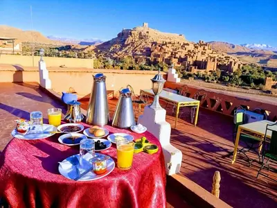 a table with food and drinks on top of a roof at La Fibule D'or in Aït Ben Haddou